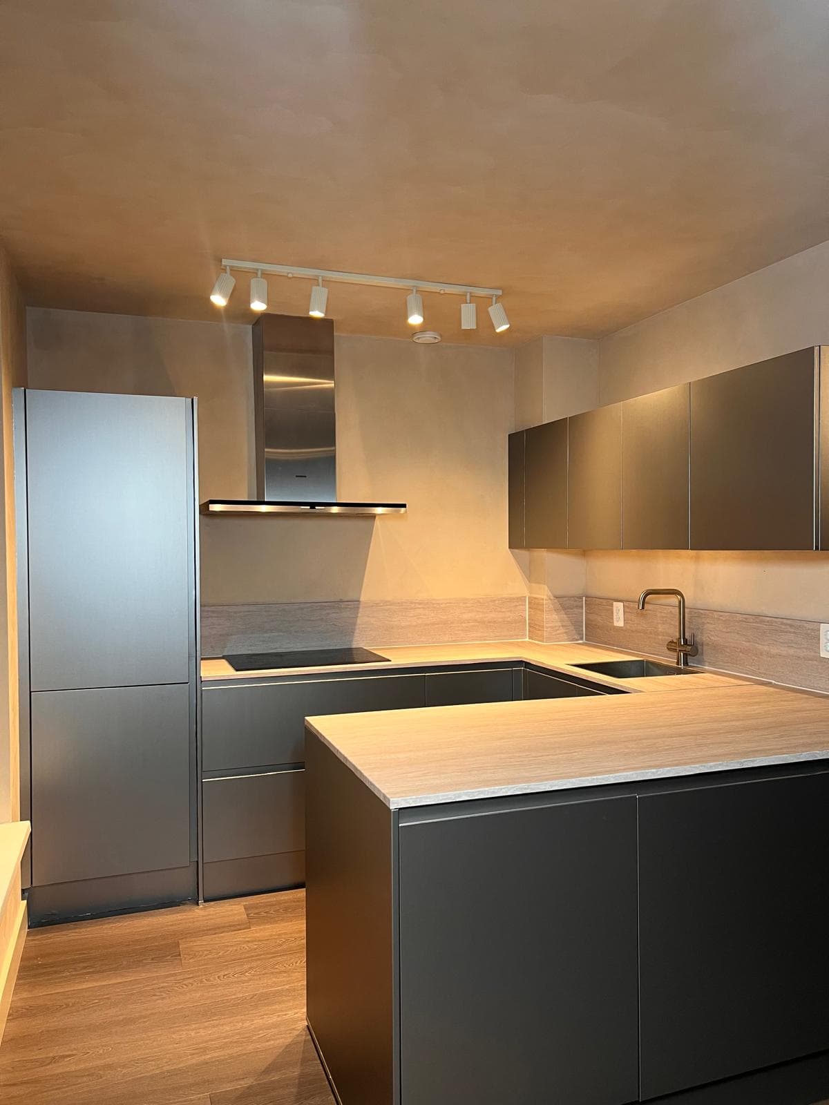 Keuken gewrapt in antraciet met houtlook fronten