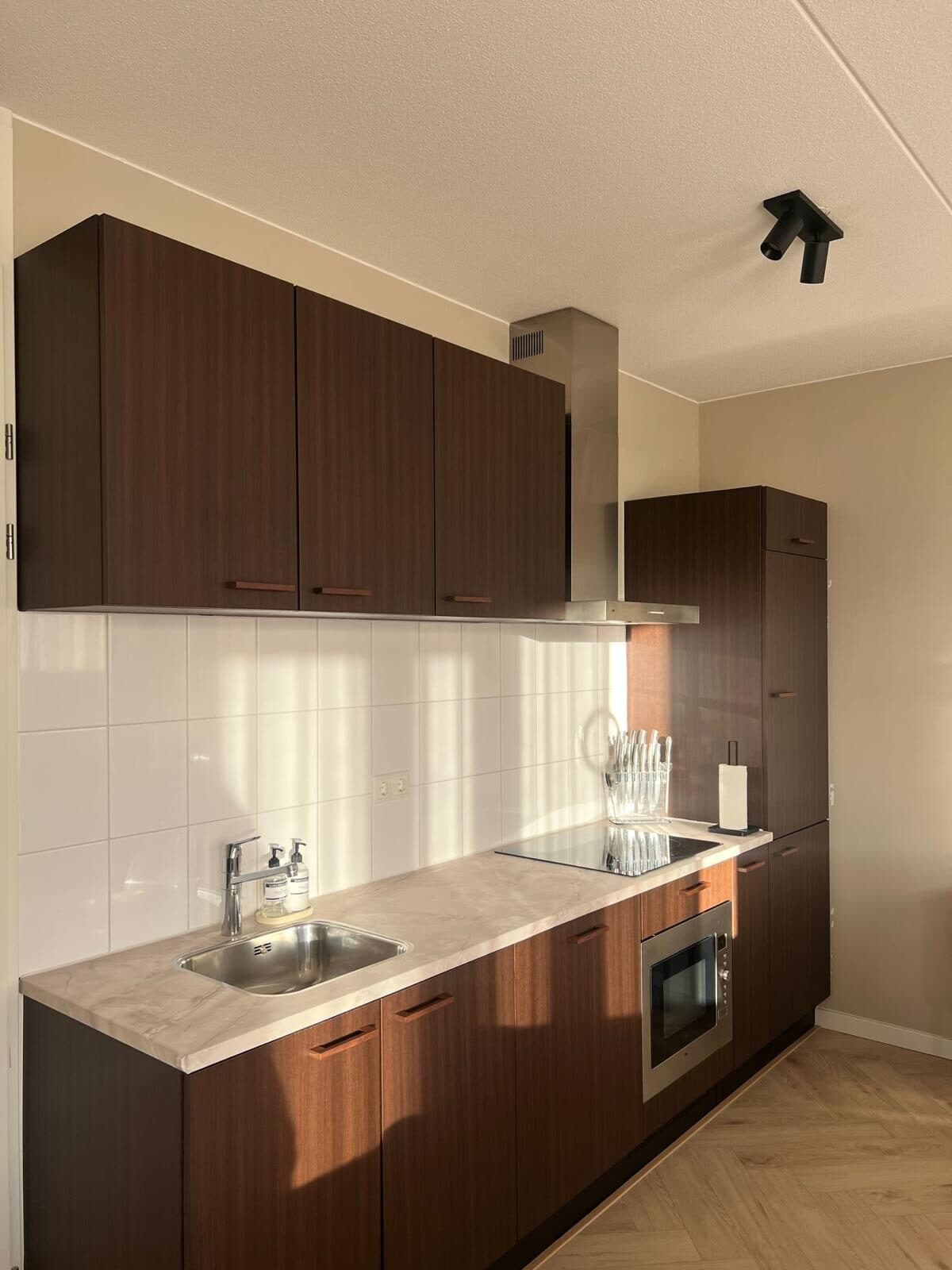 Dezelfde keuken na het wrappen in warme houtlook door Wrapify Interiors